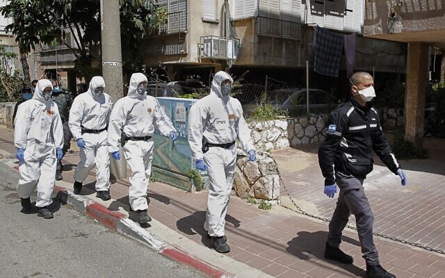 Des policiers israéliens, en tenue de protection, arrivent dans une yeshiva dans la ville israélienne de Bnei Brak le 2 avril 2020, pour s'assurer que les mesures de distanciation sociale imposées par les autorités israéliennes visant à freiner la propagation du nouveau coronavirus sont respectées. (Crédit : JACK GUEZ / AFP) Des policiers israéliens, en tenue de protection, arrivent dans une yeshiva dans la ville israélienne de Bnei Brak le 2 avril 2020, pour s'assurer que les mesures de distanciation sociale imposées par les autorités israéliennes visant à freiner la propagation du nouveau coronavirus sont respectées. (Crédit : JACK GUEZ / AFP)