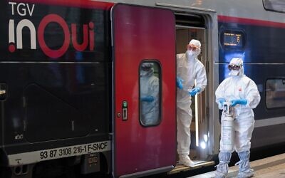 Le personnel médical attend qu'un patient infecté par le COVID-19 soit embarqué à bord d'un train à grande vitesse TGV médicalisé à la gare de Strasbourg, dans l'est de la France, le 3 avril 2020, lors de l'évacuation de 24 patients vers des hôpitaux de Bordeaux dans le sud-ouest de la France. (Crédit : PATRICK HERTZOG / POOL / AFP)