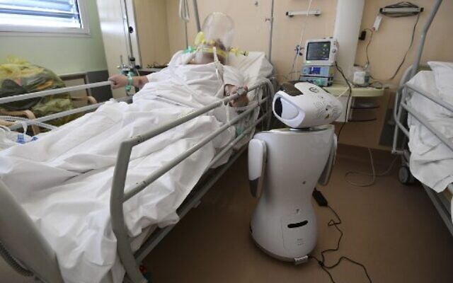 L'un des six robots de l'hôpital Circolo di Varese se tient près d'un patient, le 3 avril 2020, afin d’aider le personnel de santé du département de médecine de haute intensité à soigner douze patients souffrant de l'épidémie de coronavirus. (Crédit : Miguel MEDINA / AFP) L'un des six robots de l'hôpital Circolo di Varese se tient près d'un patient, le 3 avril 2020, afin d’aider le personnel de santé du département de médecine de haute intensité à soigner douze patients souffrant de l'épidémie de coronavirus. (Crédit : Miguel MEDINA / AFP)
