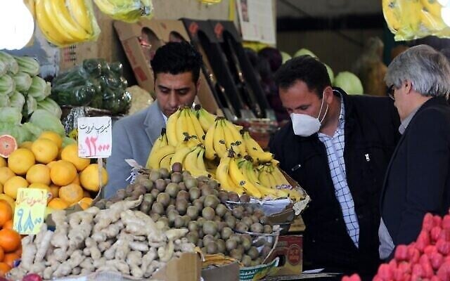 Des Iraniens achètent des fruits sur un marché de la capitale Téhéran, pendant la crise de la nouvelle pandémie de coronavirus, le 5 avril 2020. (Crédit : ATTA KENARE / AFP)