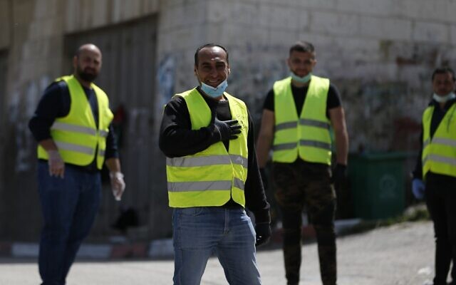 Des bénévoles palestiniens s'occupent d'un barrage pour mesurer la température des habitants à l'entrée du village d'Ein Yabrud, situé à proximité de Ramallah. Des civils ont été déployés le long de routes rurales de la Cisjordanie pour réaliser des contrôles en pleine épidémie de COVID-19, le 6 avril 2020. 
(Photo par ABBAS MOMANI / AFP)