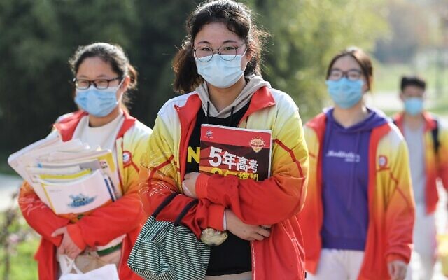 Des élèves de troisième année du secondaire portant des masques arrivent à l'école après que l'ouverture du trimestre a été retardée en raison de l'épidémie de coronavirus COVID-19, à Bozhou dans la province de l'Anhui, à l'est de la Chine, le 7 avril 2020 (Crédit : Photo STR / AFP) Des élèves de troisième année du secondaire portant des masques arrivent à l'école après que l'ouverture du trimestre a été retardée en raison de l'épidémie de coronavirus COVID-19, à Bozhou dans la province de l'Anhui, à l'est de la Chine, le 7 avril 2020 (Crédit : Photo STR / AFP)