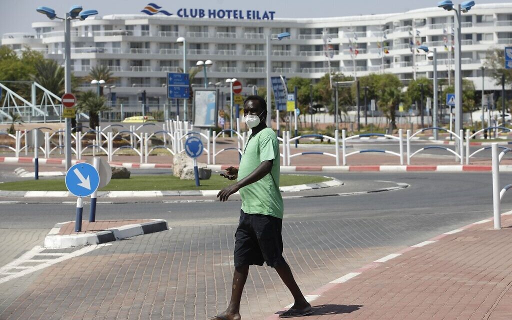 Un homme portant un masque facial protecteur se promène dans la ville de villégiature d'Eilat, au sud d'Israël, le 17 avril 2020, en pleine pandémie de coronavirus. (Crédit : MENAHEM KAHANA / AFP)