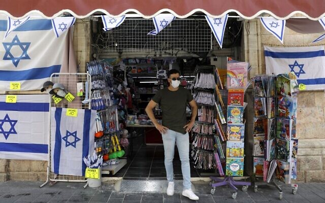 Le propriétaire d'un magasin devant son échoppe, après l'allègement du confinement, à Jérusalem, le 21 avril 2020. (Crédit : MENAHEM KAHANA / AFP) Le propriétaire d'un magasin devant son échoppe, après l'allègement du confinement, à Jérusalem, le 21 avril 2020. (Crédit : MENAHEM KAHANA / AFP)