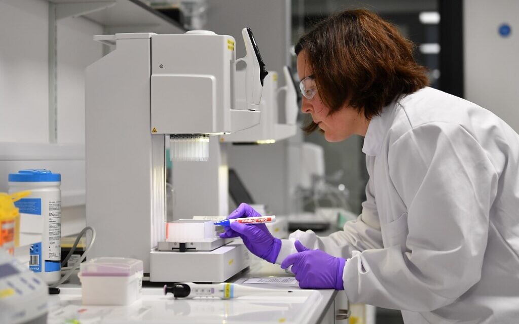 Des scientifiques volontaires traitent des échantillons prélevés sur des personnes testées pour le nouveau coronavirus, dans un laboratoire récemment dédié au traitement des échantillons COVID-19 par la Medicines Discovery Catapult, au Lighthouse Lab du parc Alderley dans le Cheshire, dans le nord de l'Angleterre, le 22 avril 2020. (Crédit : Paul ELLIS / AFP)