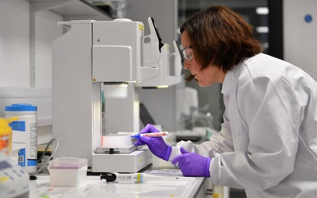 Des scientifiques volontaires traitent des échantillons prélevés sur des personnes testées pour le nouveau coronavirus, dans un laboratoire récemment dédié au traitement des échantillons COVID-19 par la Medicines Discovery Catapult, au Lighthouse Lab du parc Alderley dans le Cheshire, dans le nord de l'Angleterre, le 22 avril 2020. (Crédit : Paul ELLIS / AFP)