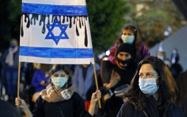 Des Israéliens portant des masques de protection et vêtus de noir participent à une manifestation sur la place Rabin de Tel Aviv, le 25 avril 2020 (Crédit : JACK GUEZ / AFP) Des Israéliens portant des masques de protection et vêtus de noir participent à une manifestation sur la place Rabin de Tel Aviv, le 25 avril 2020 (Crédit : JACK GUEZ / AFP)