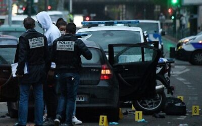 Des policiers français examinent le site où un conducteur a percuté et blessé deux policiers. L'automobiliste avait fait allégeance à l'EI, le 27 avril 2020 à Colombes. (Photo par FRANCK FIFE / AFP)