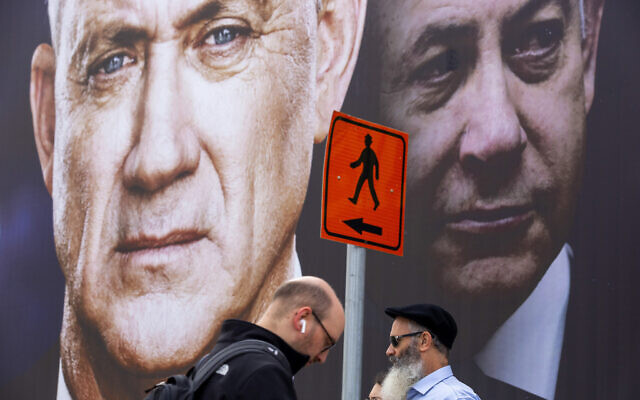 Des gens passent devant un panneau d'affichage de la campagne électorale du parti Kakhol lavan à Ramat Gan, le 23 février 2020. (AP Photo/Oded Balilty, File) Des gens passent devant un panneau d'affichage de la campagne électorale du parti Kakhol lavan à Ramat Gan, le 23 février 2020. (AP Photo/Oded Balilty, File)