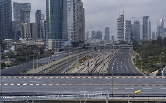 Sur cette photo du 28 mars 2020, un homme roule à bicyclette sur une route déserte lors d'un blocage de la circulation suite à des mesures visant à contenir la propagation du coronavirus, à Tel Aviv. (AP Photo/Oded Balilty)