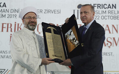 Le président turc Recep Tayyip Erdogan, à droite, reçoit un cadeau de la part du chef des Affaires religieuses de Turquie Ali Erbas lors d'un Sommet religieux africain musulman à Istanbul, le samedi 19 octobre 2019. (Service de presse présidentiel via AP, Pool )