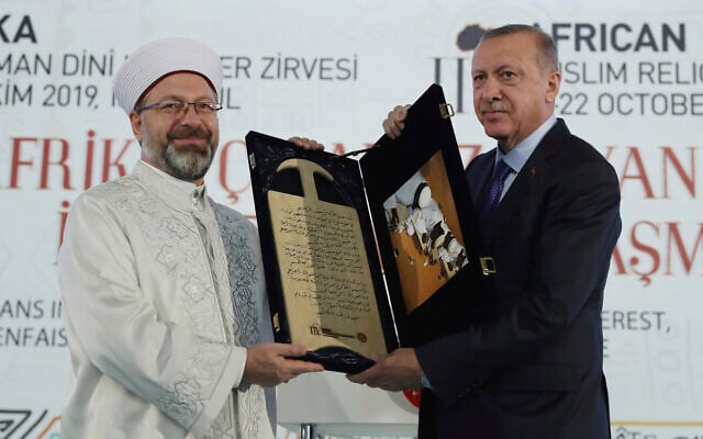 Le président turc Recep Tayyip Erdogan, à droite, reçoit un cadeau de la part du chef des Affaires religieuses de Turquie Ali Erbas lors d'un Sommet religieux africain musulman à Istanbul, le samedi 19 octobre 2019. (Service de presse présidentiel via AP, Pool ) Le président turc Recep Tayyip Erdogan, à droite, reçoit un cadeau de la part du chef des Affaires religieuses de Turquie Ali Erbas lors d'un Sommet religieux africain musulman à Istanbul, le samedi 19 octobre 2019. (Service de presse présidentiel via AP, Pool )