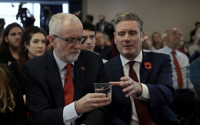 Le leader du parti du Labour britannique, Jeremy Corbyn, à gauche, donne un verre d'eau au secrétaire d'Etat au Brexit du cabinet fantôme, Keir Starmer, lors d'un événement de campagne sur le Brexit à Harlow, en Angleterre, le 5 novembre 2019 (Crédit : AP Photo/Matt Dunham) Le leader du parti du Labour britannique, Jeremy Corbyn, à gauche, donne un verre d'eau au secrétaire d'Etat au Brexit du cabinet fantôme, Keir Starmer, lors d'un événement de campagne sur le Brexit à Harlow, en Angleterre, le 5 novembre 2019 (Crédit : AP Photo/Matt Dunham)