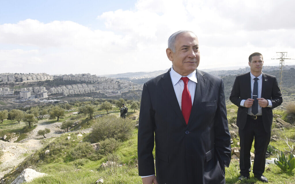 Le Premier ministre Benjamin Netanyahu se trouve devant une vue d'ensemble du quartier de Har Homa à Jérusalem-Est, où il a annoncé la construction d'un nouveau quartier, le 20 février 2020. (Debbie Hill/Pool via AP)