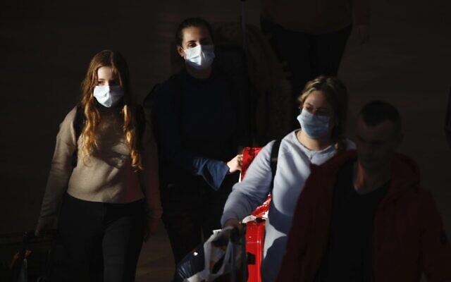 Photo d'illustration : Des voyageurs portant des masques à l'aéroport international Ben Gurion, près de Tel Aviv, en Israël, le 27 février 2020 (Crédit : AP Photo/Ariel Schalit) Photo d'illustration : Des voyageurs portant des masques à l'aéroport international Ben Gurion, près de Tel Aviv, en Israël, le 27 février 2020 (Crédit : AP Photo/Ariel Schalit)