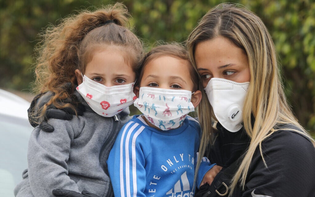 Une famille porte des masques pour se protéger du coronavirus, le 18 mars 2020 (Crédit : Yossi Aloni/Flash90)