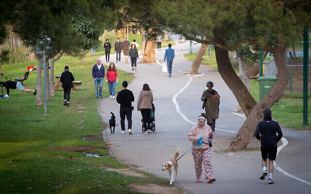 Des Israéliens promènent leur chien et font du sport au parc HaYarkon de Tel Aviv, le 22 mars 2020. (Crédit : Miriam Alster/Flash90) Des Israéliens promènent leur chien et font du sport au parc HaYarkon de Tel Aviv, le 22 mars 2020. (Crédit : Miriam Alster/Flash90)