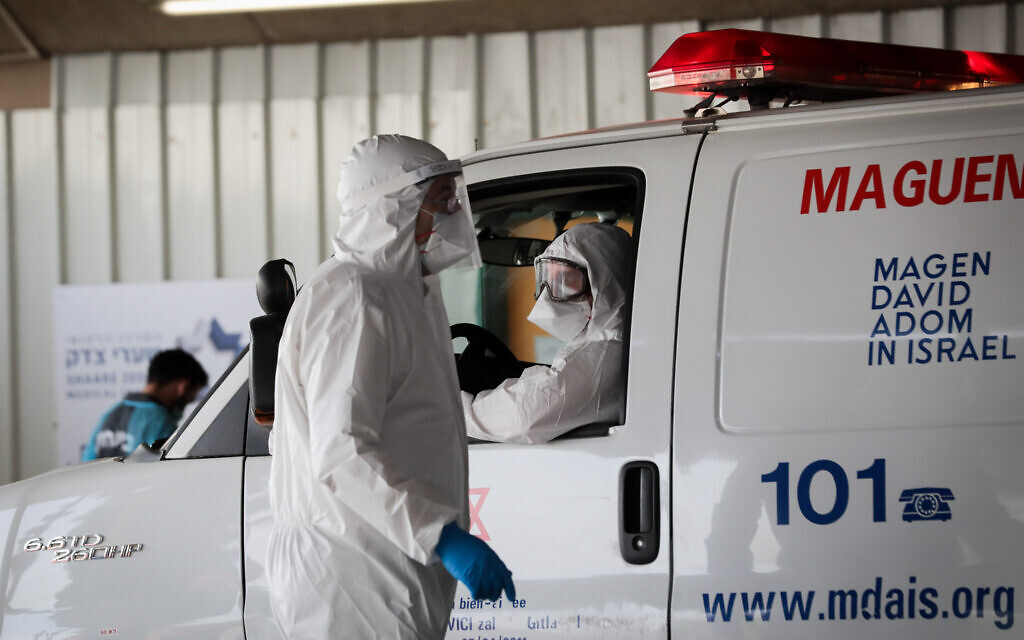 Des agents du Magen David Adom portant des vêtements de protection comme mesure préventive contre le coronavirus, vus lors de l'évacuation d'un homme suspecté de coronavirus à l'hôpital Shaare Zedek de Jérusalem, le 30 mars 2020. (Yossi Zamir/Flash90)