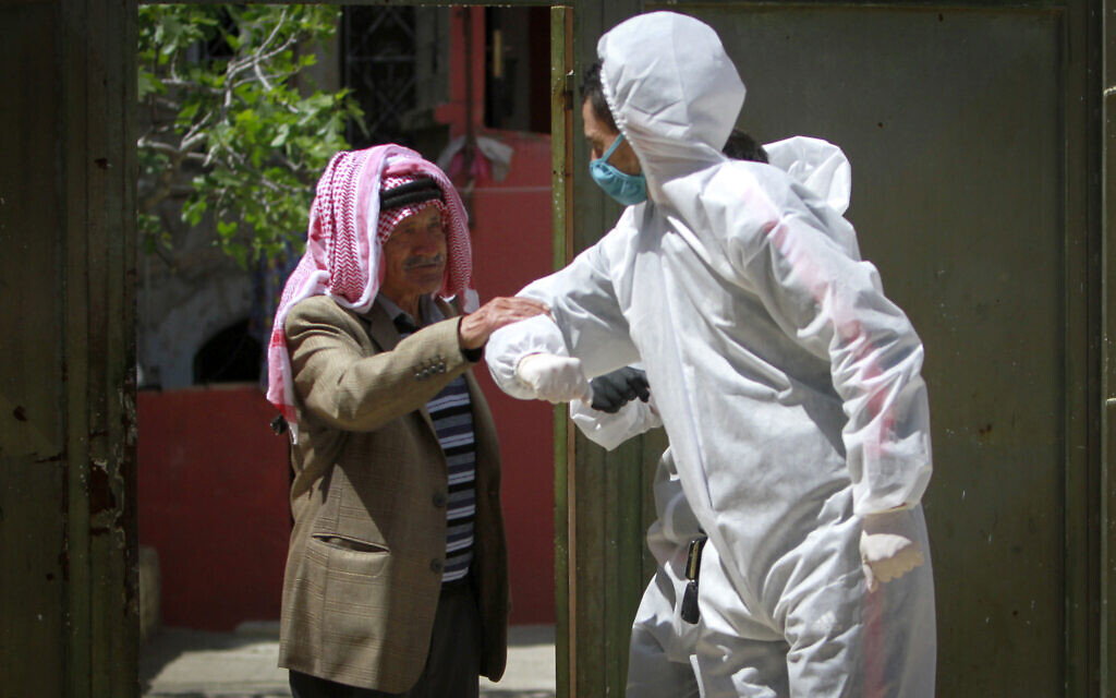 Des travailleurs palestiniens nettoient les rues et les maisons à Naplouse, en Cisjordanie, dans le cadre de la lutte contre le coronavirus le 3 avril. (Crédit :  Nasser Ishtayeh/Flash90)