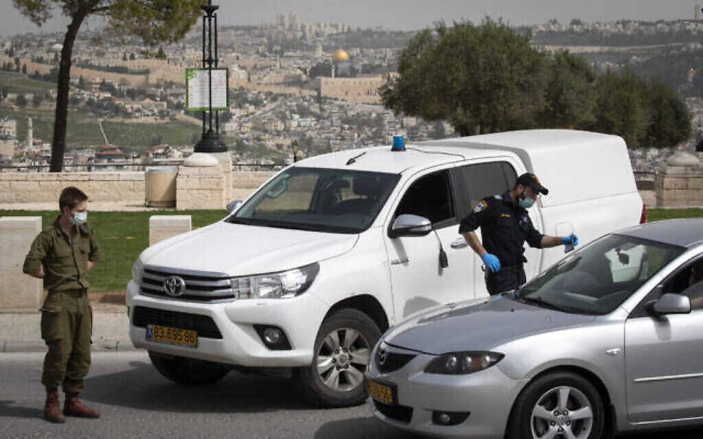 Des policiers et des soldats israéliens à un poste de contrôle temporaire à Jérusalem, pour vérifier que les gens ne désobéissent pas aux ordres du gouvernement visant à empêcher la propagation du coronavirus, 5 avril 2020 (Crédit : Olivier Fitoussi / Flash90)