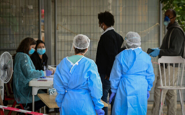 Des personnels médicaux en habits de protection sur un site de dépistage au coronavirus, dans le sud de Tel Aviv, le 6 avril 2020 (Crédit : Avshalom Sassoni/Flash90)