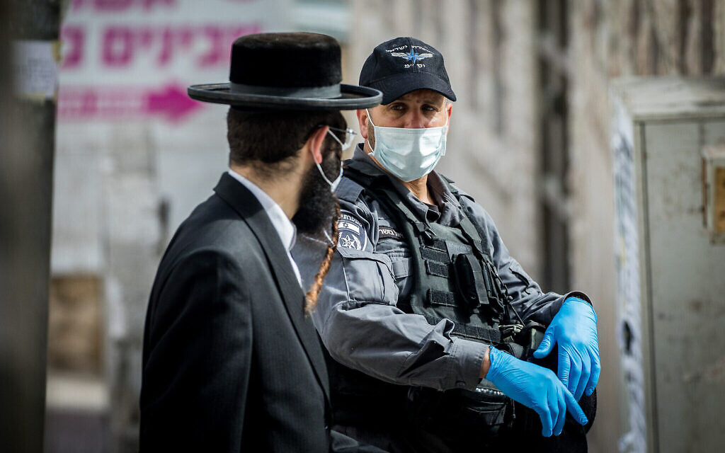 Des policiers ferment des synagogues et donnent des amendes aux Juifs Haredi dans le quartier de Boukharim à Jérusalem, suite aux restrictions imposées par le gouvernement dans le cadre des efforts pour contenir la propagation du coronavirus, le 6 avril 2020. (Yonatan Sindel/Flash90)
