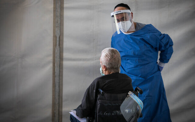 Un professionnel de santé reçoit un patient du coronavirus à l'hôpital Shaaré Zedek à Jérusalem, le 16 avril 2020. (Crédit : Nati Shohat/Flash90) Un professionnel de santé reçoit un patient du coronavirus à l'hôpital Shaaré Zedek à Jérusalem, le 16 avril 2020. (Crédit : Nati Shohat/Flash90)