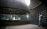 Un agent de la sécurité de Yad Vashem se tient devant le Hall des Noms vide du Musée mémorial de la Shoah à Yad Vashem à Jérusalem pendant la crise du coronavirus, le 19 avril 2020. (Crédit : Yonatan Sindel/Flash90)