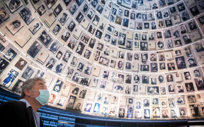 Un agent de la sécurité de Yad Vashem se tient devant la salle des Noms vide du Musée mémorial de la Shoah à Yad Vashem à Jérusalem, le 19 avril 2020. (Crédit : Yonatan Sindel/Flash90)