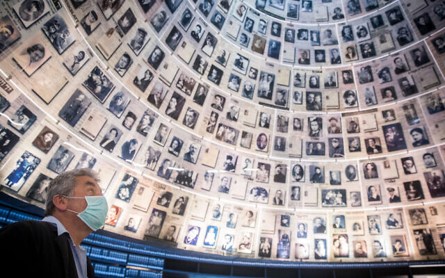 Un agent de la sécurité de Yad Vashem se tient devant la salle des Noms vide du Musée mémorial de la Shoah à Yad Vashem à Jérusalem, le 19 avril 2020. (Crédit : Yonatan Sindel/Flash90)
