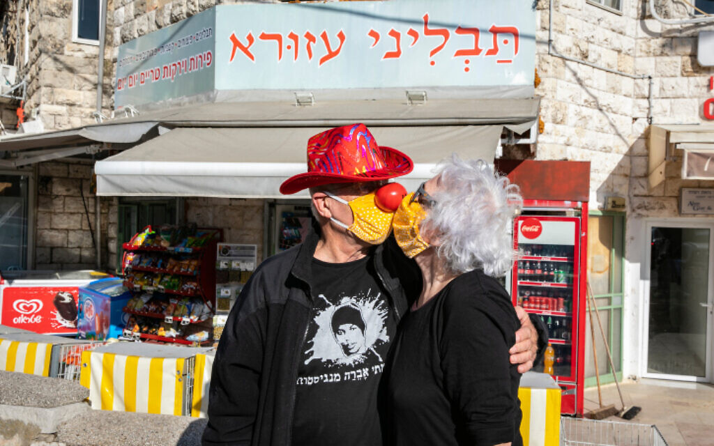 Un couple d'Israéliens, masqués, s'embrassasse à Jérusalem, le 26 avril 2020. (Crédit : Olivier Fitoussi/Flash90)