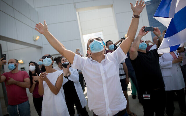 Ronni Gamzu. PDG de l'hôpital Sourasky de Tel Aviv, salue la parade aérienne qui survole Ichilov, lors de Yom HaAtsmaout, le 29 avril 2020. (Crédit : Miriam Alster/Flash90)