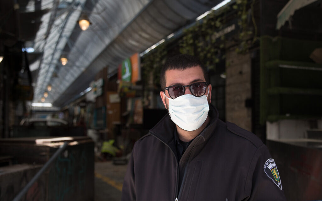 Un garde au marché de Mahane Yehuda fermé, à Jérusalem, le 29 mars 2020. (Crédit : Nati Shohat/Flash90)