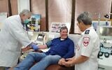 Un patient du coronavirus guéri (au centre) donne du plasma pour une expérimentation d'un nouveau traitement aux anticorps, avec Eilat Shinar, à droite. (Crédit : Magen David Adom)