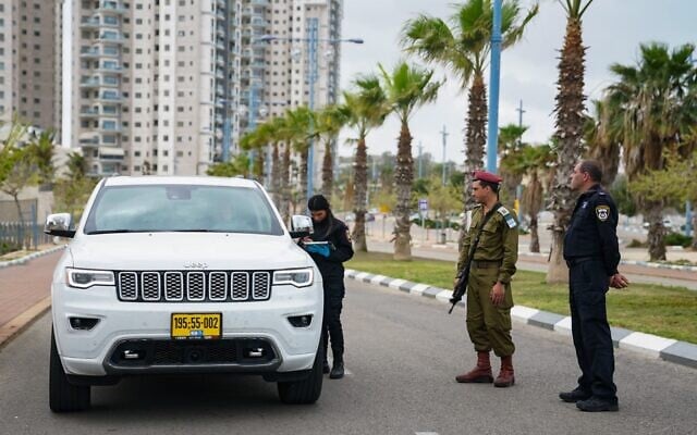 Un soldat de Tsahal et la police à un checkpoint durant la pandémie de coronavirus, le 2 avril 2020. (Crédit : armée israélienne) Un soldat de Tsahal et la police à un checkpoint durant la pandémie de coronavirus, le 2 avril 2020. (Crédit : armée israélienne)