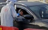 Un agent du service médical d'urgence Magen David Adom réalise un prélèvement dans le cadre d'un test de dépistage du coronavirus sur un site en drive-in à Tamra, dans le nord d'Israël, le 31 mars 2020. (Crédit : Ahmad GHARABLI / AFP)
