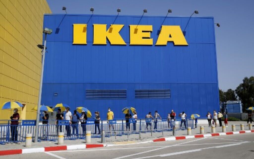 Des clients s'efforcent de maintenir une distance de sécurité les uns des autres alors qu'ils font la queue pour entrer à IKEA dans la ville côtière de Netanya, le 22 avril 2020, après que les autorités ont assoupli certaines mesures imposées pendant la crise du coronavirus. (Photo par JACK GUEZ / AFP)