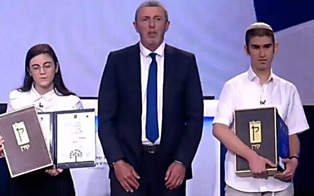 Le ministre de l'Education Rafi Peretz (centre) avec la lauréate du Quizz international de la Bible Ruth Cohen (gauche) et le finaliste Moshe Giladi (droite), le 29 avril 2020. (Capture d'écran : Onzième chaîne)