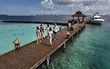 Des touristes étrangers arrivant dans une résidence de vacances sur l'île de Kurumba, aux Maldives, le 12 février 2012. (Gemunu Amarasinghe/AP)