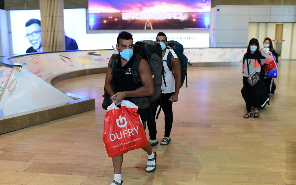 Des voyageurs israéliens, qui avaient été bloqués en Amérique du sud, arrivent à l'aéroport Ben Gurion, le 23 mars 2020, depuis Sao Paolo via New York. (Tomer Neuberg/Flash90)