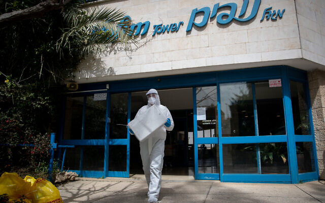 Un membre du Magen David Adom portant une tenue de protection dépiste pour le coronavirus des habitants de la Tour Nofim, une résidence senior, à Jérusalem le 27 mars 2020. (Yonatan Sindel/Flash90)