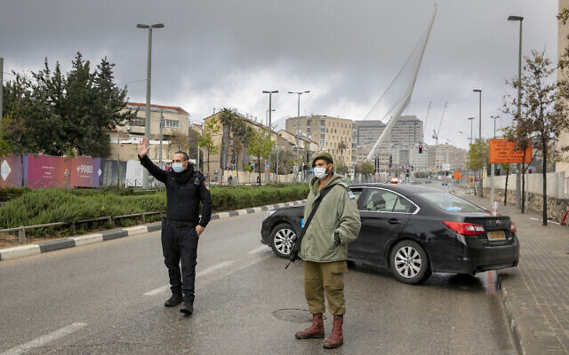 Un officier de police et un soldat israélien à un barrage temporaire à Jérusalem le 11 avril 2020 pour s'assurer que la population respecte bien le règles de confinement contre le COVID-19.(Olivier Fitoussi/Flash90) Un officier de police et un soldat israélien à un barrage temporaire à Jérusalem le 11 avril 2020 pour s'assurer que la population respecte bien le règles de confinement contre le COVID-19.(Olivier Fitoussi/Flash90)