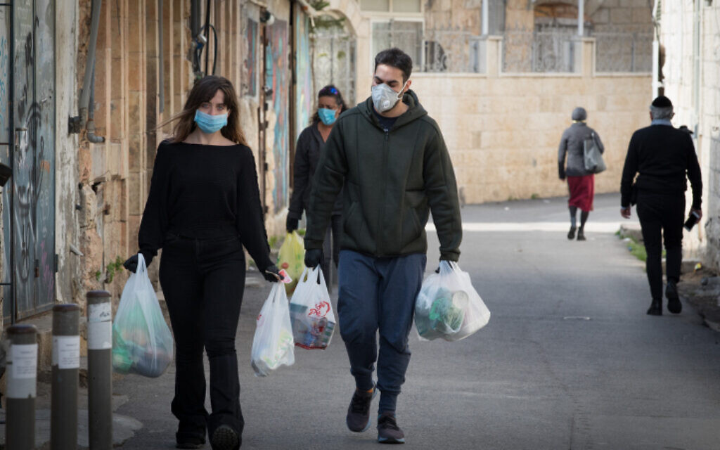 Des personnes avec des sacs de courses à Jérusalem, le 12 avril 2020. (Nati Shohat/Flash90) Des personnes avec des sacs de courses à Jérusalem, le 12 avril 2020. (Nati Shohat/Flash90)