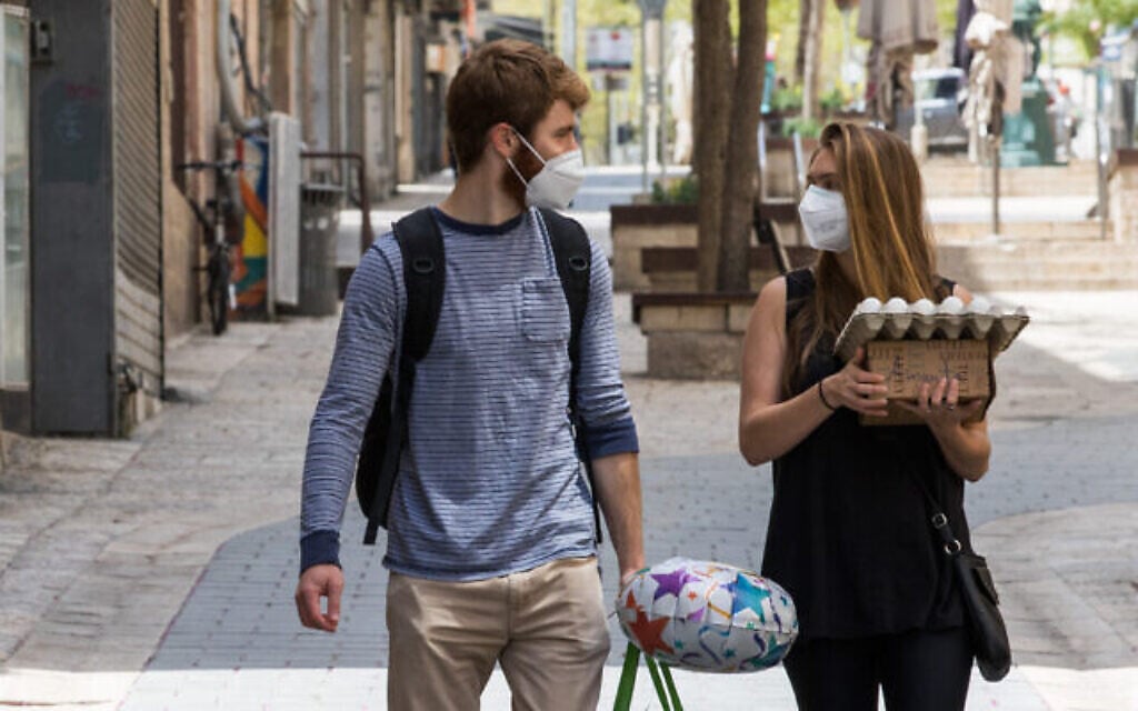 Des Israéliens portant des masques marchent avec des œufs dans la rue Ben Yehuda à Jérusalem, le 16 avril 2020. (Olivier Fitoussi/Flash90)