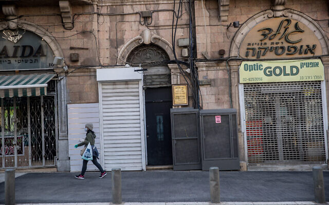 Une femme marche devant des magasins fermés dans le centre-ville de Jérusalem, le 20 avril 2020. (Yonatan Sindel/Flash90) Une femme marche devant des magasins fermés dans le centre-ville de Jérusalem, le 20 avril 2020. (Yonatan Sindel/Flash90)