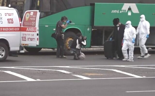 Un Israélien suspecté d'avoir sciemment pris un bus pour Jérusalem après avoir été testé positif au COVID-19 est accompagné par des urgentistes du
Magen David Adom du bus vers une ambulance le 5 avril 2020 (Capture d'écran : Douzième chaîne) Un Israélien suspecté d'avoir sciemment pris un bus pour Jérusalem après avoir été testé positif au COVID-19 est accompagné par des urgentistes du
Magen David Adom du bus vers une ambulance le 5 avril 2020 (Capture d'écran : Douzième chaîne)