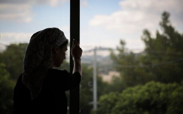 Une Juive orthodoxe regarde par la fenêtre d'un foyer pour femmes battues à Beit Shemesh, le 15 juillet 2014. (Crédit : Hadas Parush/Flash90) Une Juive orthodoxe regarde par la fenêtre d'un foyer pour femmes battues à Beit Shemesh, le 15 juillet 2014. (Crédit : Hadas Parush/Flash90)