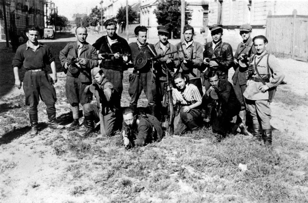 Photo célèbre du groupe de résistants "Avengers" dirigé par Abba Kovner. Benjamin Levin est agenouillé devant (avec son chapeau) et pointe son arme. (Domaine public)