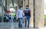 Des individus portent un masque de protection, dans les rues de Doha, au Qatar, le 17 mai 2020. (Crédit : KARIM JAAFAR / AFP)