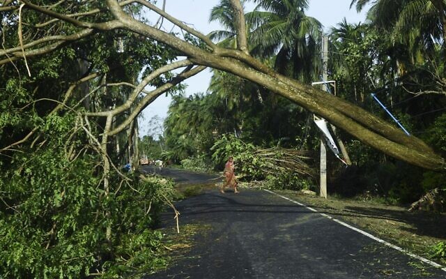 Une femme retire les débris de la rue endommagée par le cyclone Amphan à Midnapore, au Bengale occidental, le 21 mai 2020. (Crédit : Dibyangshu SARKAR / AFP)